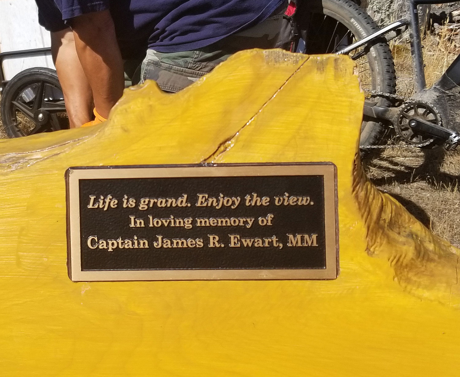 Bench plaque: "Life is grand. Enjoy the view. In loving memory of Captain James R. Ewart, MM"