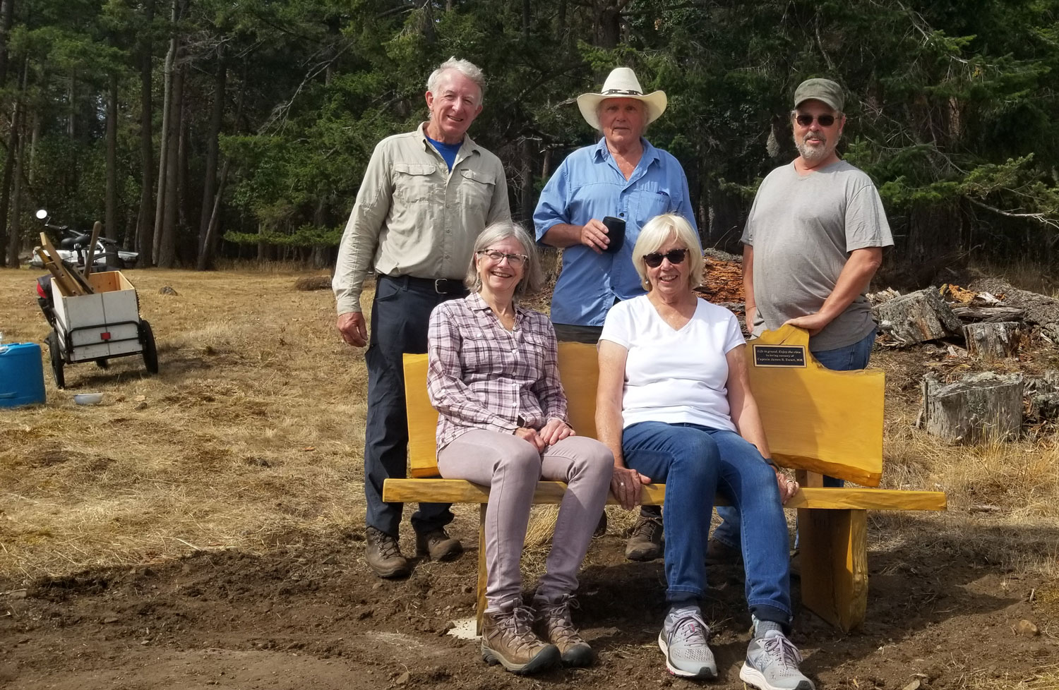 group of people with a handcrafted wooden memorial bench