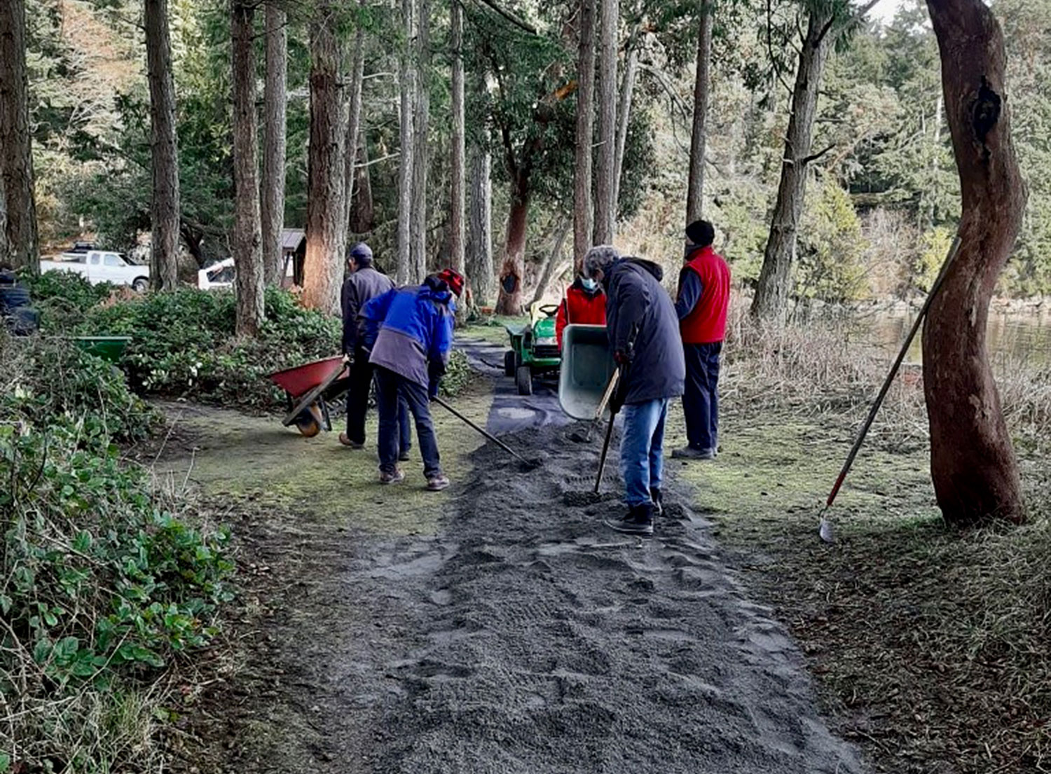 Group of people spreading gravel mix on new accessible pathway