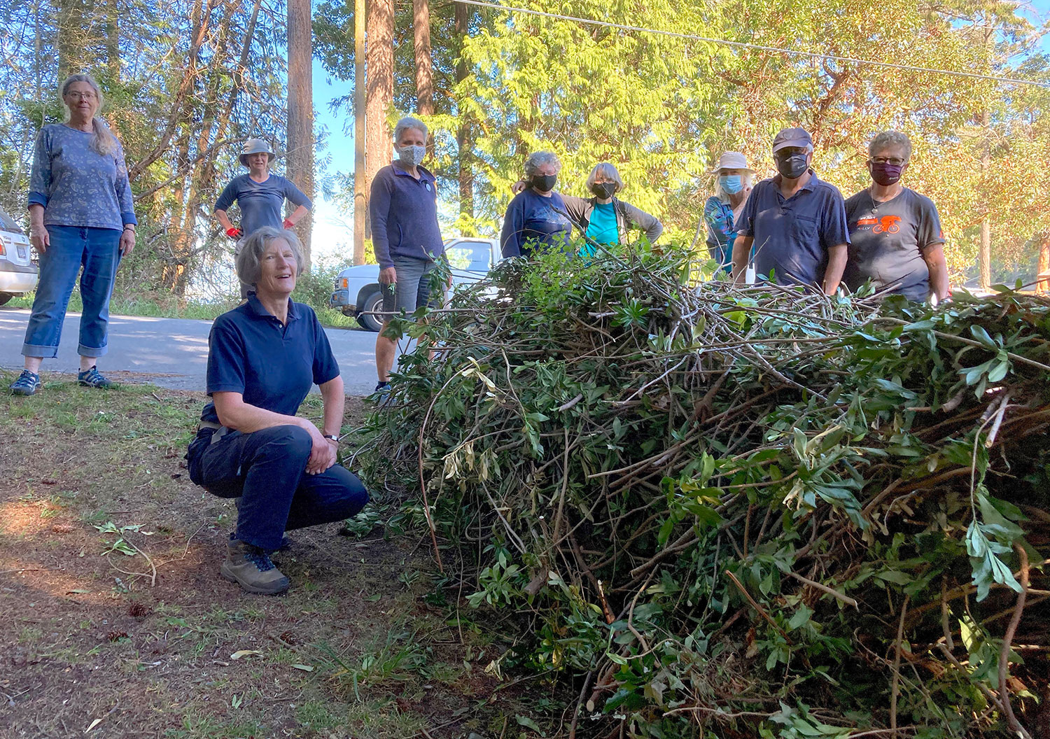 Group of volunteers with large daphne pile.