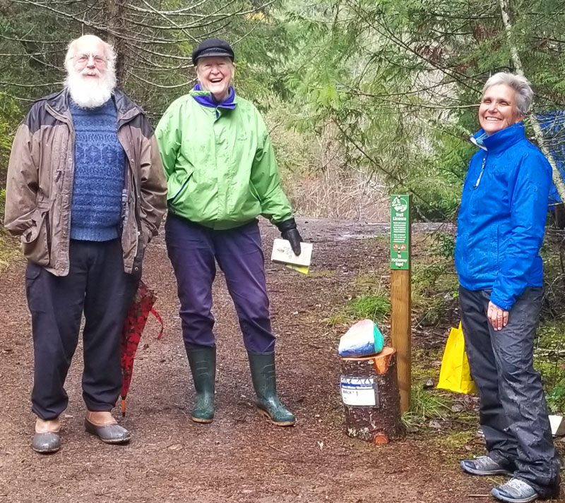 Three people standing near the trail marker for the first walk on the Great Winter Walkabout.