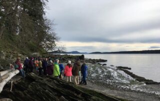A group of people on a beach on a winter day.