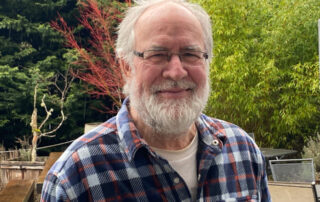 A photo of a smiling bearded man.