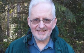 A bearded man in glasses smiles into the camera.