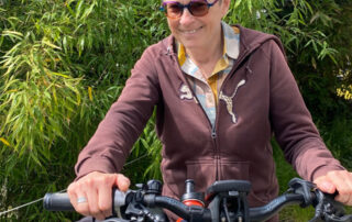 A smiling woman with a bicycle.