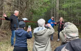 The Wilkinson Woods celebration 707 acquisition ribbon-cutting: GaLTT president Hugh Skinner holds the ribbon for RDN Director Vanessa Craig to cut.