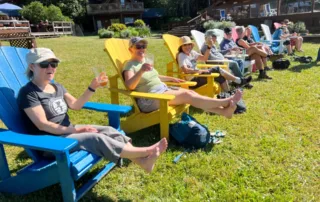 GaLTT's 2025 End to End Walk - walkers relax on a long line of adirondack chairs